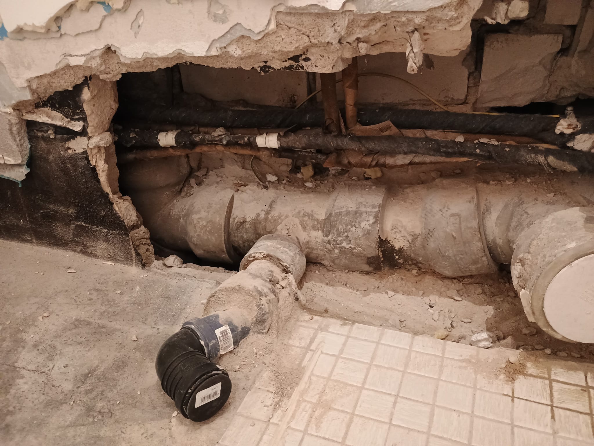 Asbestkanalausbau zwischen vielen Leitungen